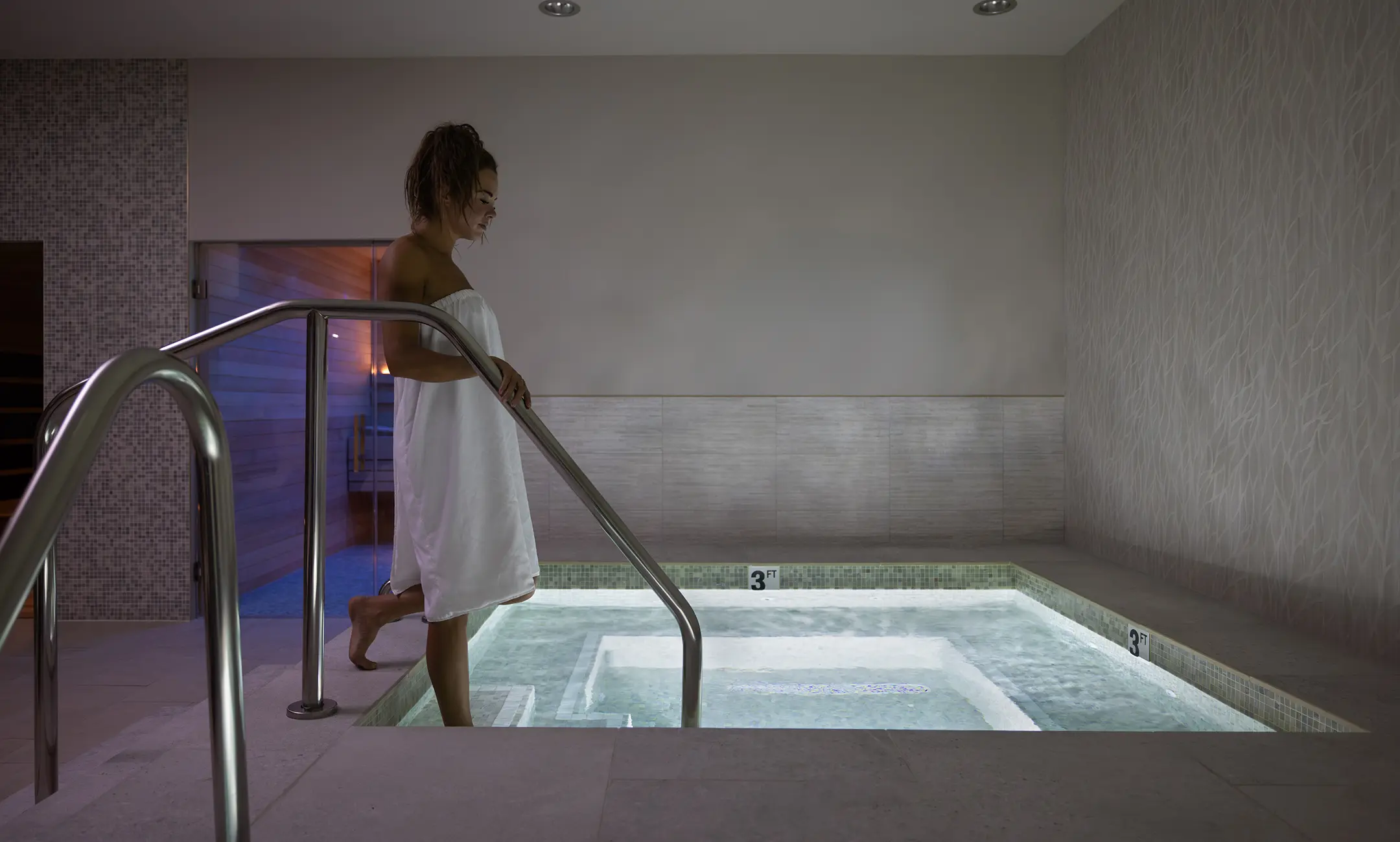 Woman stepping into cold plunge at the Spa at Promontory.