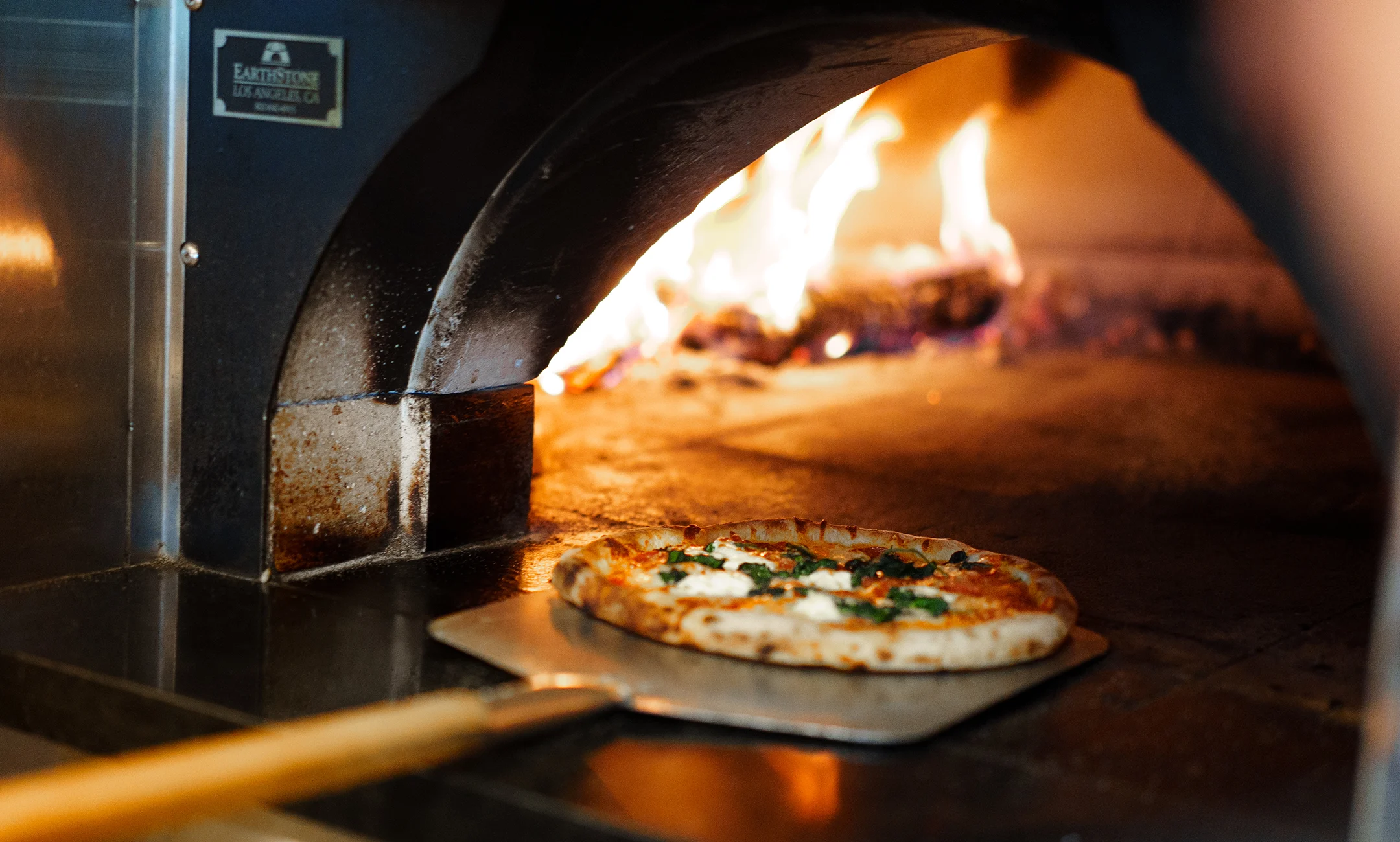 Pizza being pulled out of the brick oven at Sage restaurant in Promontory.